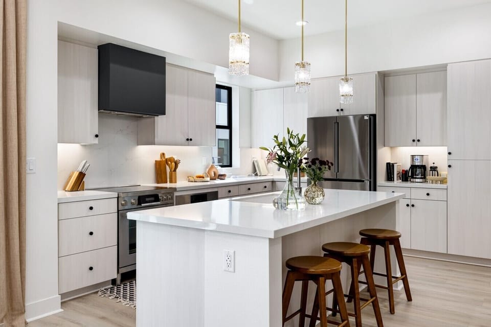 Bright white kitchen with a large island and bar seating, fully equipped for cooking up your favorite meals.