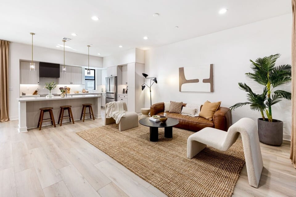 Open-concept living space with a leather sofa, cozy accent chairs, and plenty of natural light.
