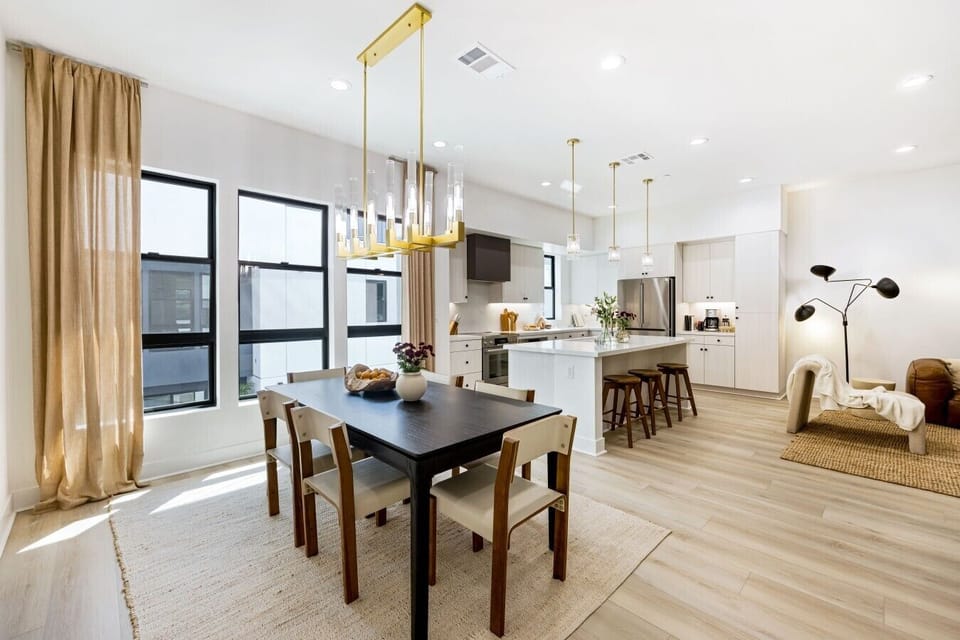 An open, light-filled layout connecting the dining table, kitchen, and lounge area seamlessly.
