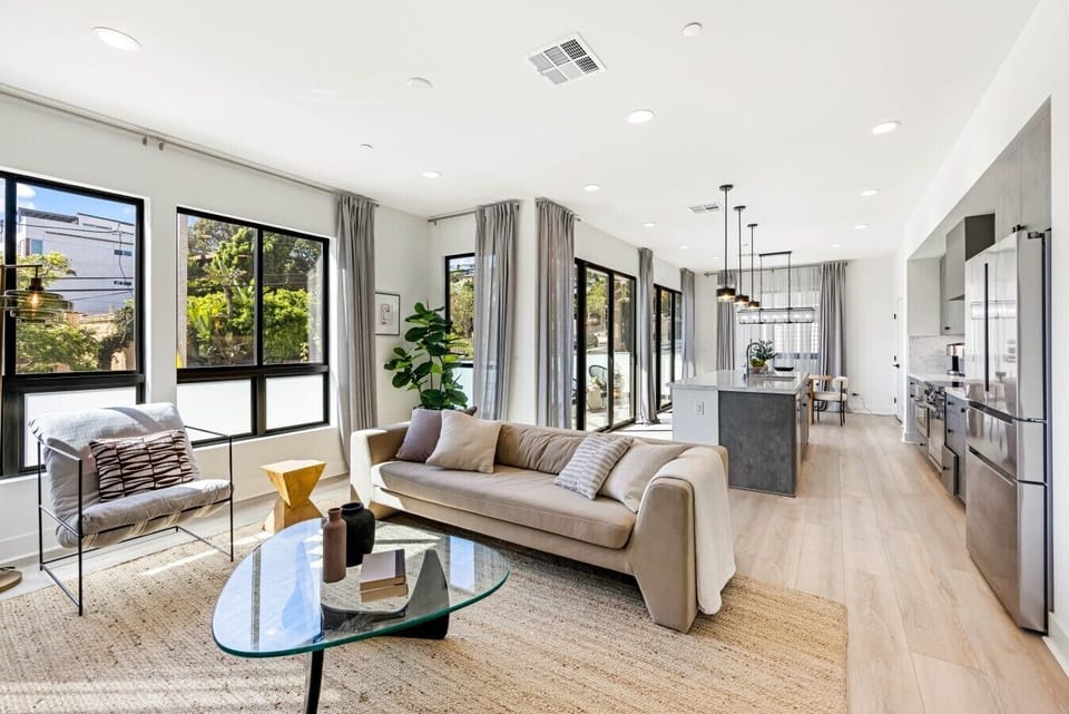 Floor-to-ceiling windows fill this living space with natural light and views of the tree-lined street below.