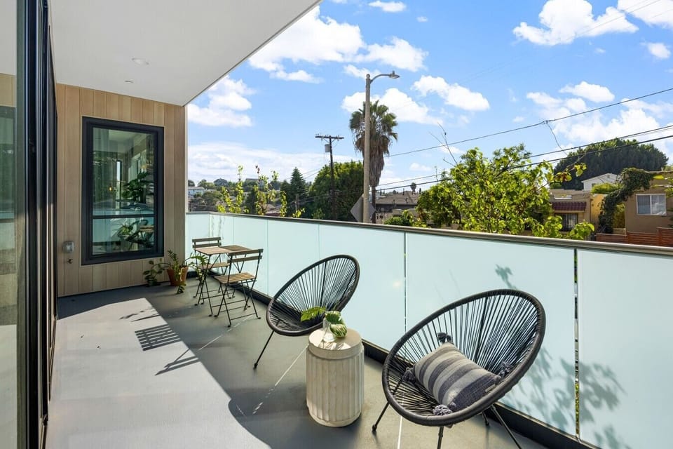 The private rooftop deck offers lounge seating and treetop views, a great spot to relax outdoors.