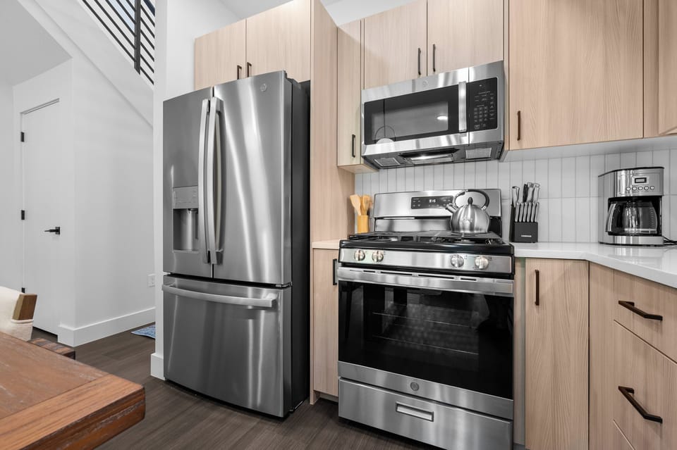 Fully equipped kitchen featuring stainless steel appliances and a gas range.