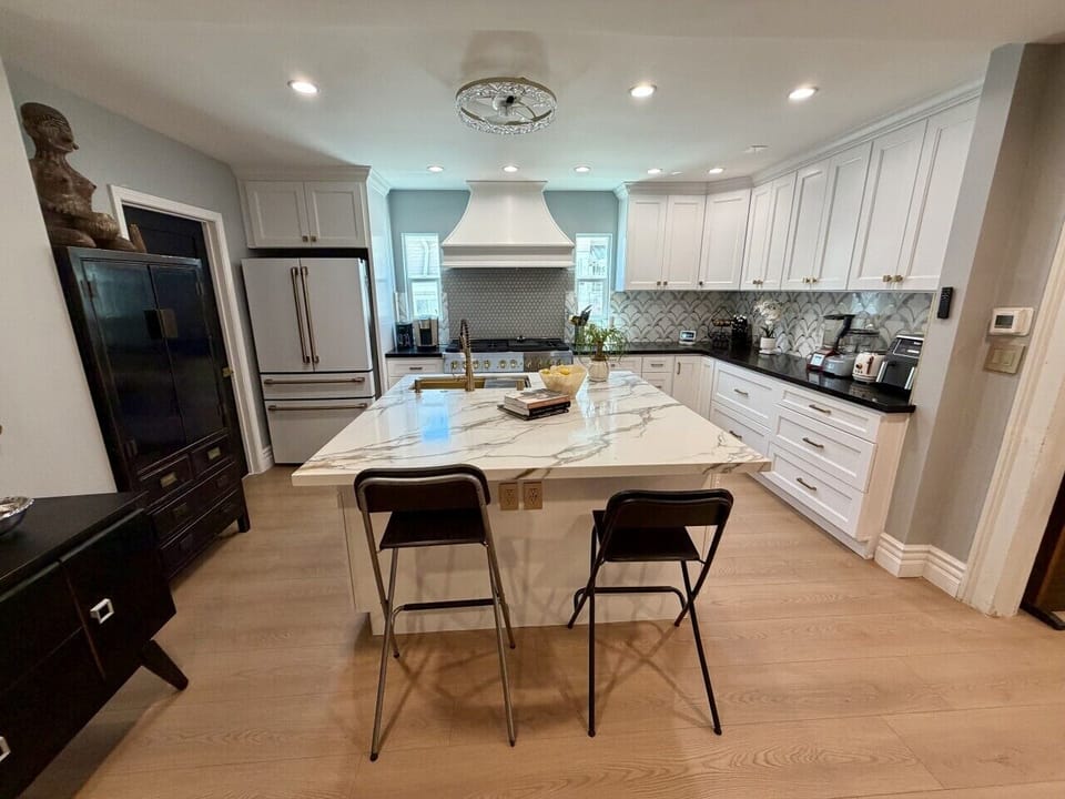 The stunning chef`s kitchen is the heart of the home, featuring dramatic black cabinetry, elegant gold hardware, and a spacious island that`s perfect for cooking, gathering, or entertaining. Thoughtfully designed with both style and functionality in mind,