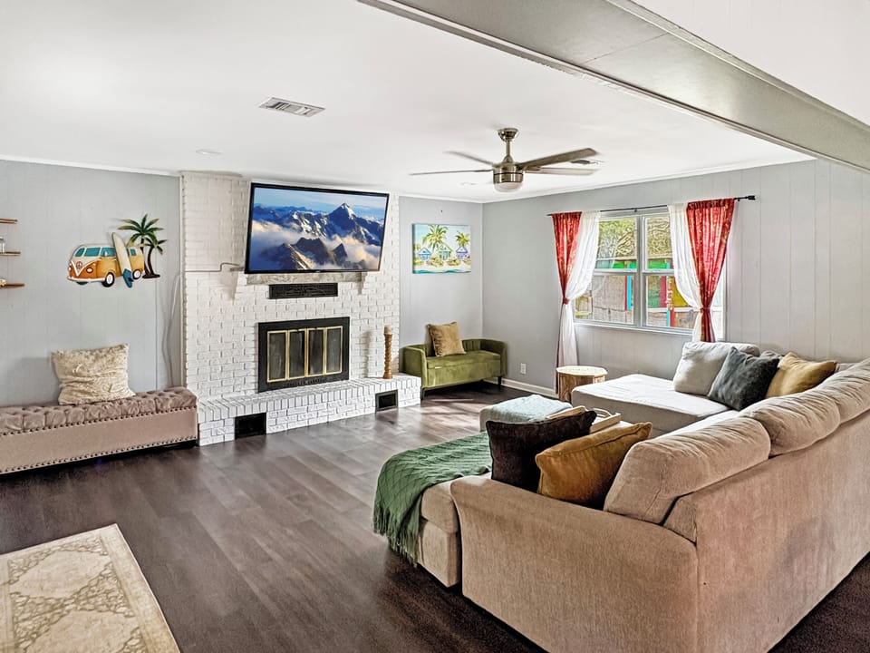 Bright living room with large sectional, fireplace, and mounted TV