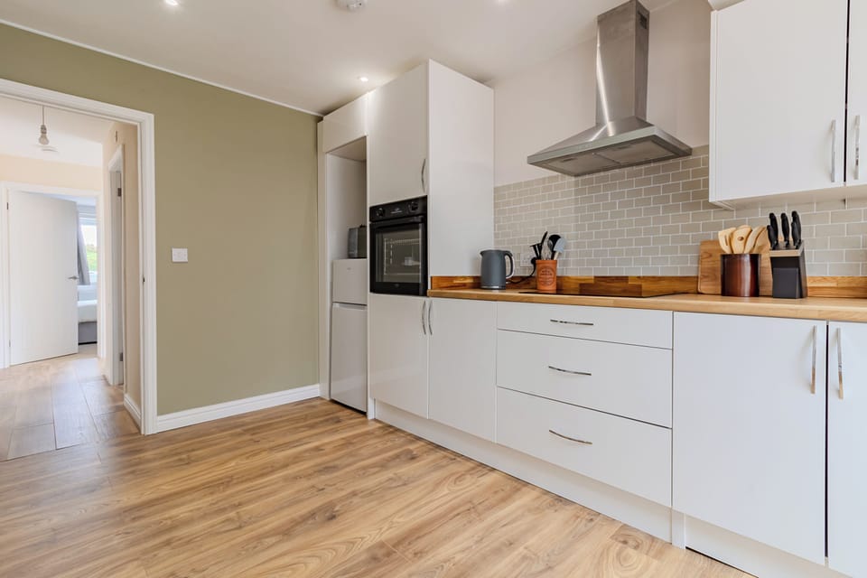 Kitchen area featuring fitted kitchen units, fridge, freezer, microwave - Washing machine
- Built-in dishwasher
- Sink and taps
- LED lighting and heat detector