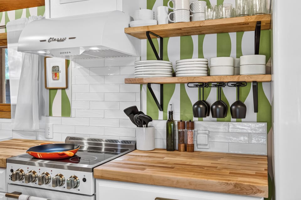 Stylish kitchen with open shelving, butcher-block counters, and bold design