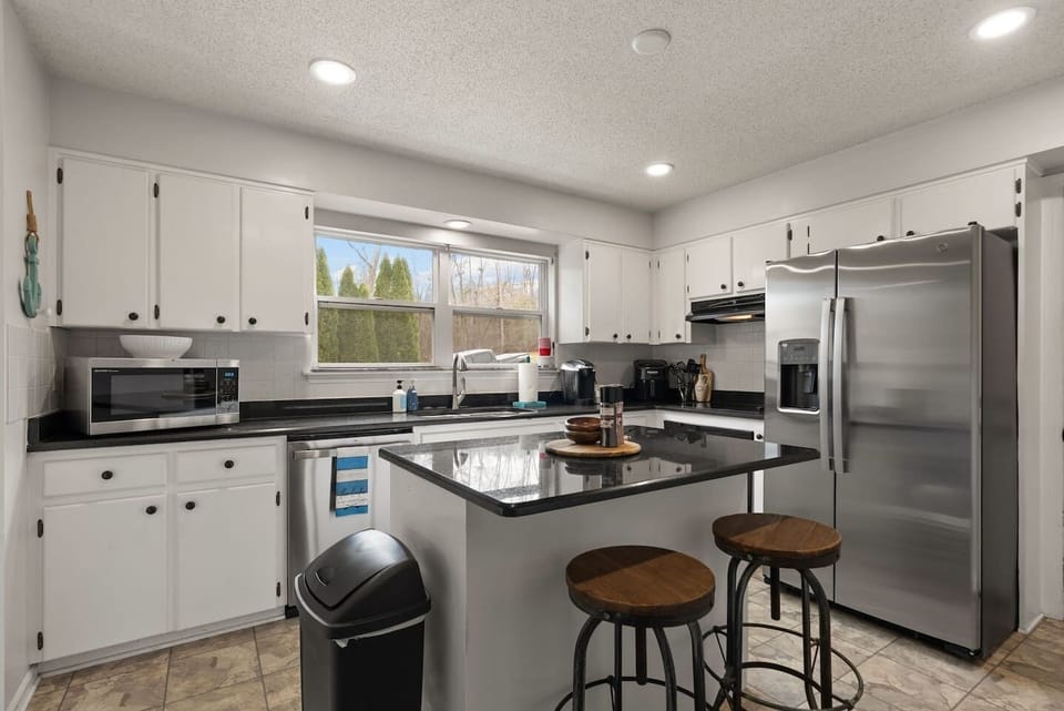 Our kitchen has an island that seats two and all the appliances you need- full sized refrigerator, microwave, coffee machine, and dishwasher! We also have all of the cooking utensil, pots, and pans you need to cook for your gathering. 