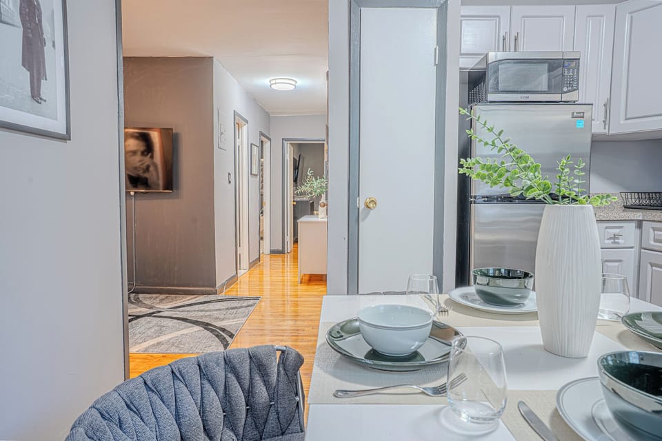 A modern kitchen with white cabinets, stainless steel appliances, and a cozy dining setup.