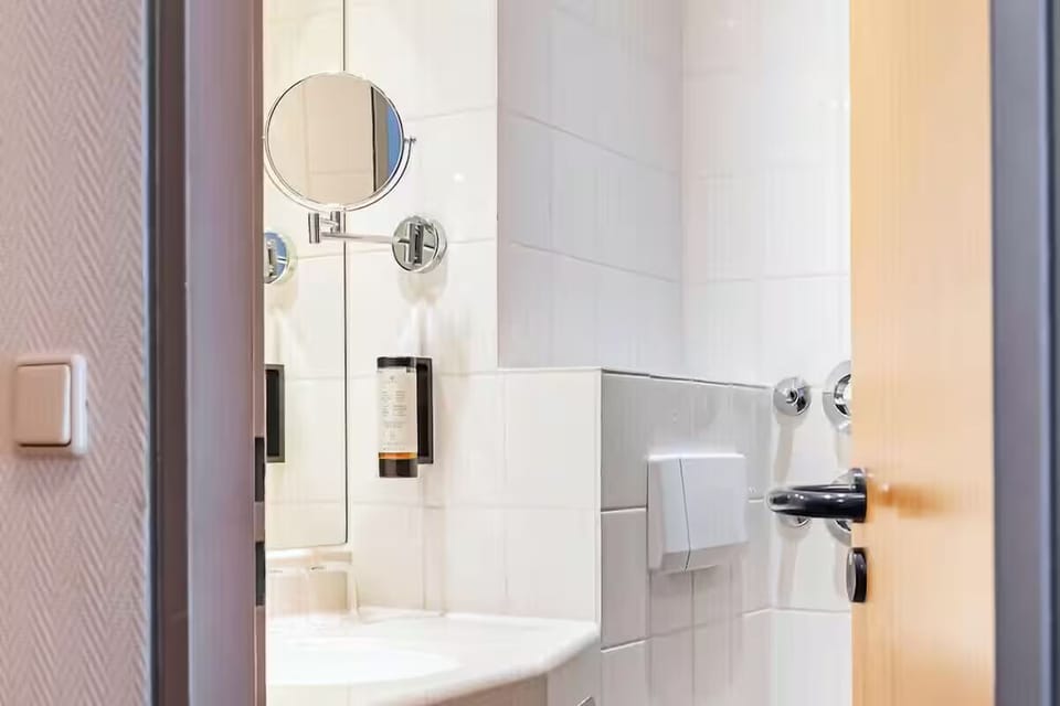 Step into a crisp bathroom with convenient mirror and toiletries.