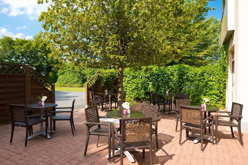 Sip morning coffee on the sunny terrace under leafy trees.