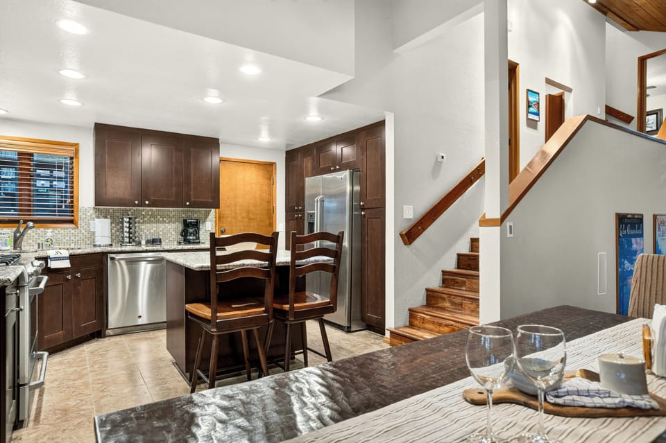 Kitchen and dining area with island seating, stainless steel appliances, and easy access to the upper level.