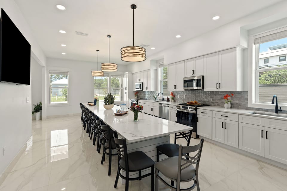 Expansive chef’s kitchen with double appliances, oversized island seating, and sleek modern finishes.