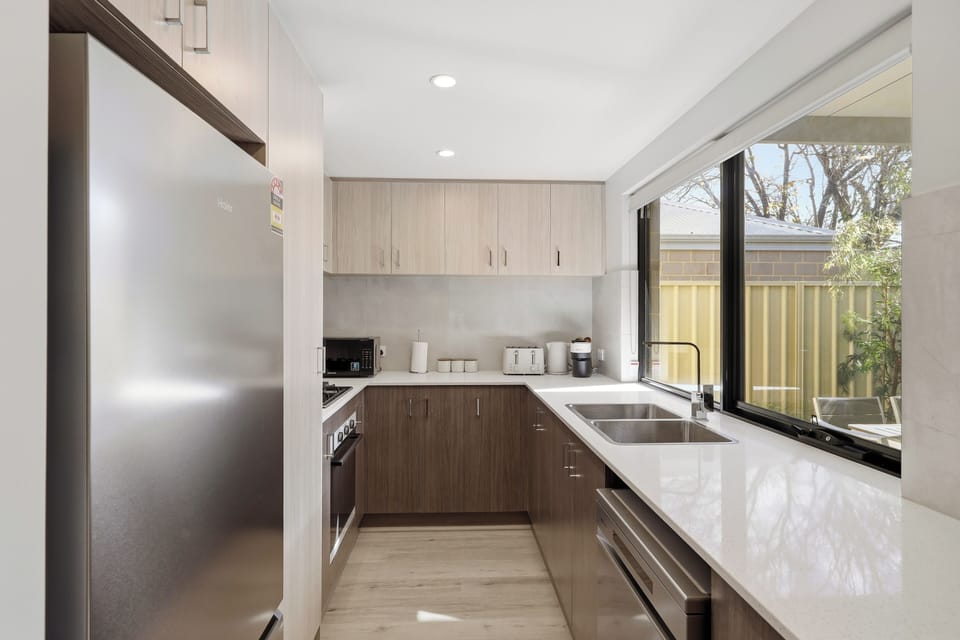 Enjoy home-cooked meals in our beautifully styled kitchen, fully equipped with premium stainless steel appliances, plenty of storage space, and a wide window looking out to the patio.