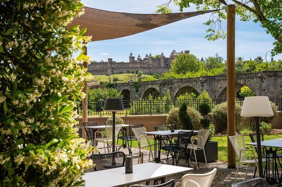 Stone-paved lounge area bathed in afternoon sun, steps from the bar that opens at 7am.