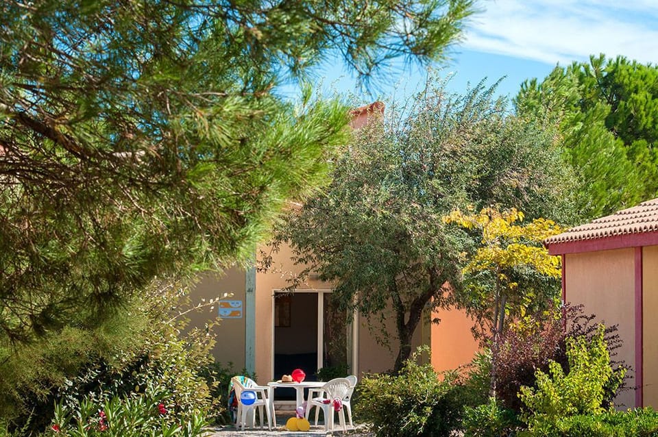 A generous private terrace nestled among pine trees and Mediterranean garden, ideal for alfresco dining.