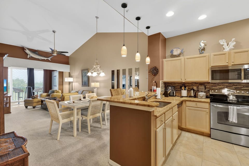 Fully-equipped kitchen, cozy dining area, and inviting living room flow seamlessly together under vaulted ceilings.