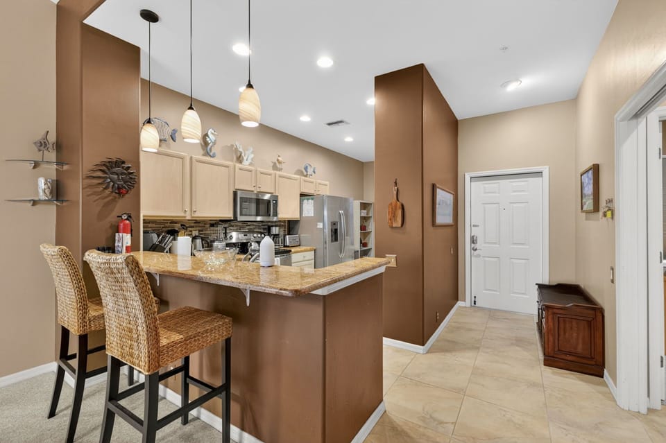 Bright, open kitchen featuring granite countertops, modern appliances, and a welcoming breakfast bar.