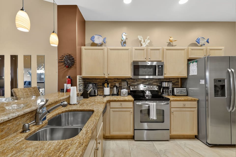 Fully equipped kitchen features granite counters and stainless appliances.