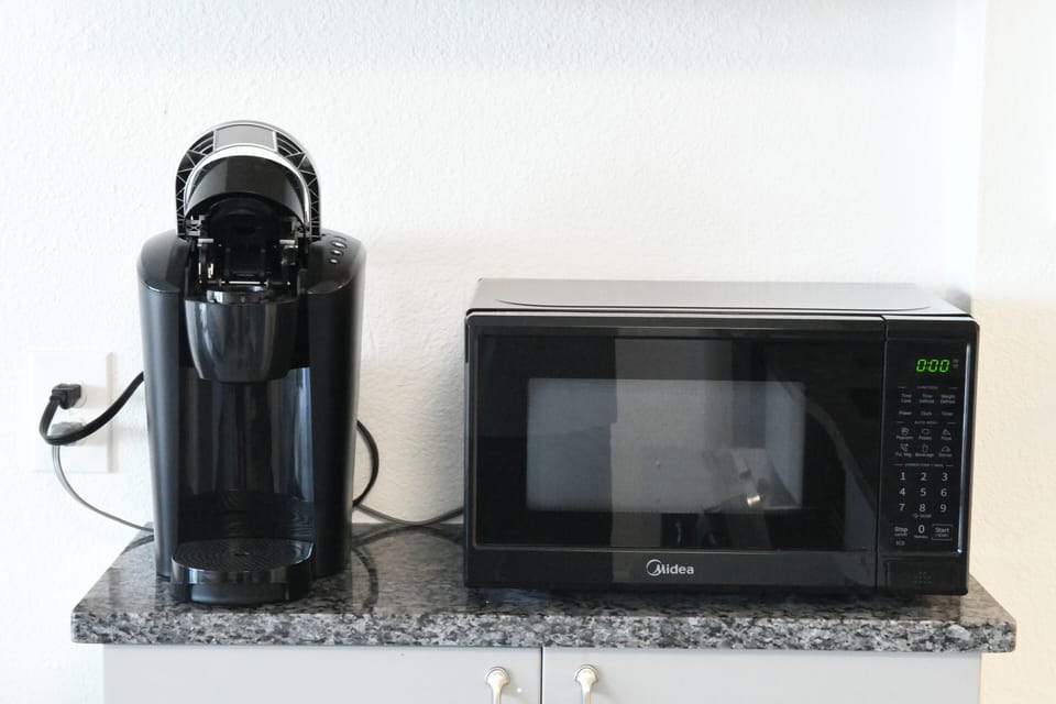 Your morning routine made easy with a sleek coffee maker and modern microwave, ready to prepare your favorite snacks and beverages throughout your stay.