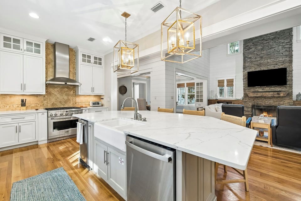 Your gourmet kitchen flows effortlessly into a cozy living space, where elegant lighting, sleek countertops, and a warm fireplace invite you to cook, relax, and gather.
