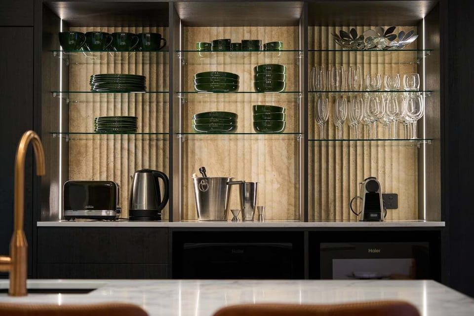 The kitchen is designed for entertaining, with coffee maker, kettle, toaster, wine fridge, bar fridge, full size fridge, induction hotplate, microwave and dishwasher.