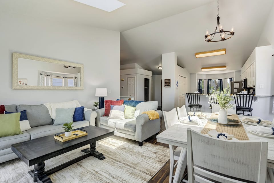 The main level welcomes you into a bright, open-concept living space featuring comfortable seating, a cozy gas fireplace, a Smart TV, and a queen sofa sleeper for additional guests.