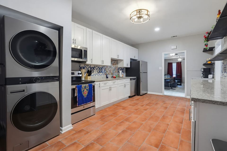 Spacious kitchen with stainless appliances, tile floors, and in-unit laundry