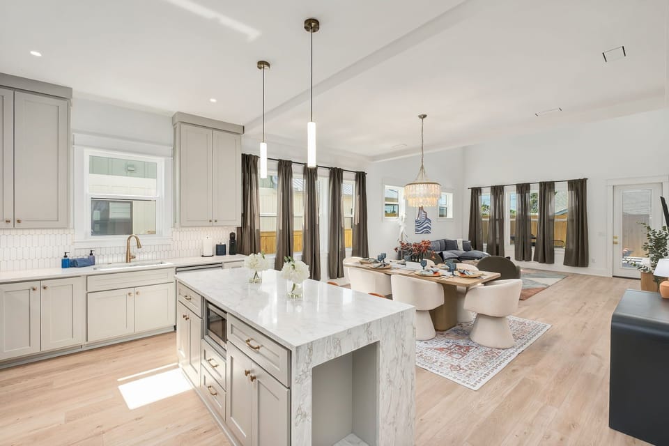 Bright open-concept kitchen, dining, and living space with luxe finishes