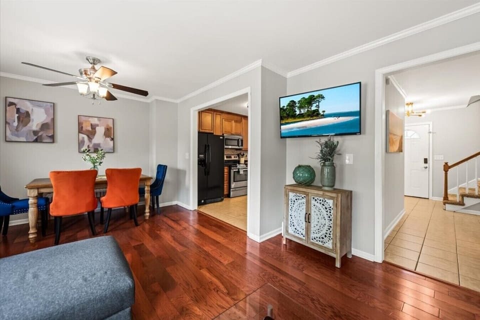 Stand in the dining area and you can see the whole ground floor at once — kitchen to the left, living room straight ahead, stairs to your right.