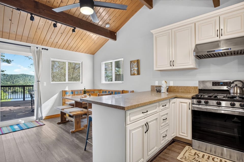 Fully equipped kitchen with white cabinetry and a breakfast bar.