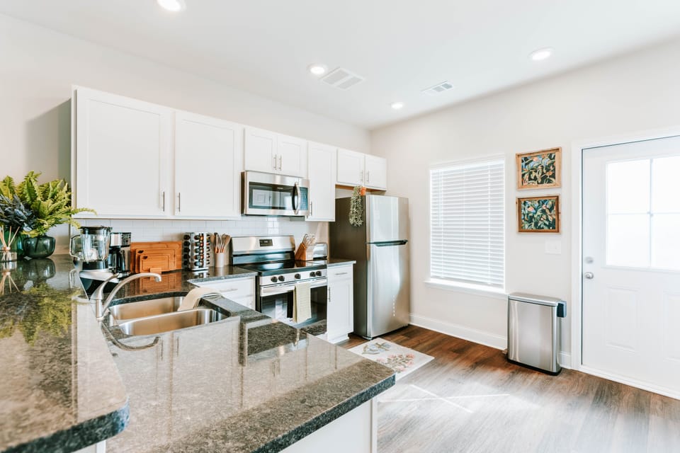 Well-equipped kitchen with a large sink, stove, and coffee setup.
