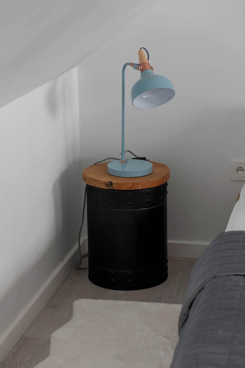 Bedside table with a reading lamp next to the double bed in the living room.
