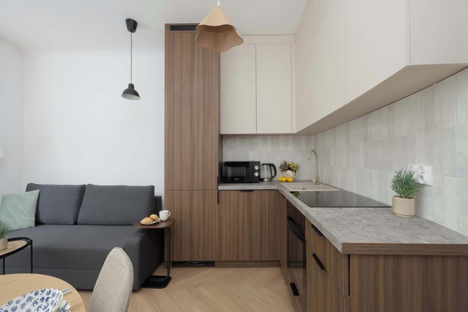 A modern kitchenette with plenty of storage and all the essentials for preparing meals. The cozy sofa creates a welcoming space to unwind after a day of sightseeing.