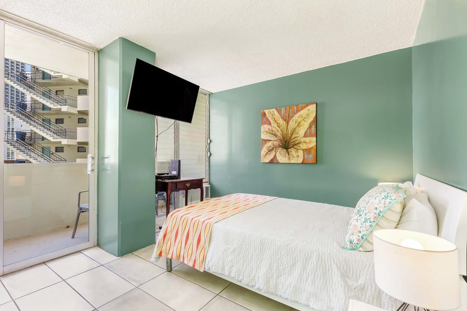 Sink into crisp white linens in your coastal-inspired bedroom with calming sage walls and a flat-screen TV for your relaxation. Step through the glass door to your private balcony with city views.