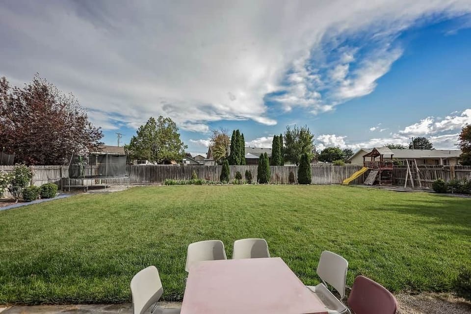 Huge fenced yard with patio seating, perfect for play and outdoor hangs