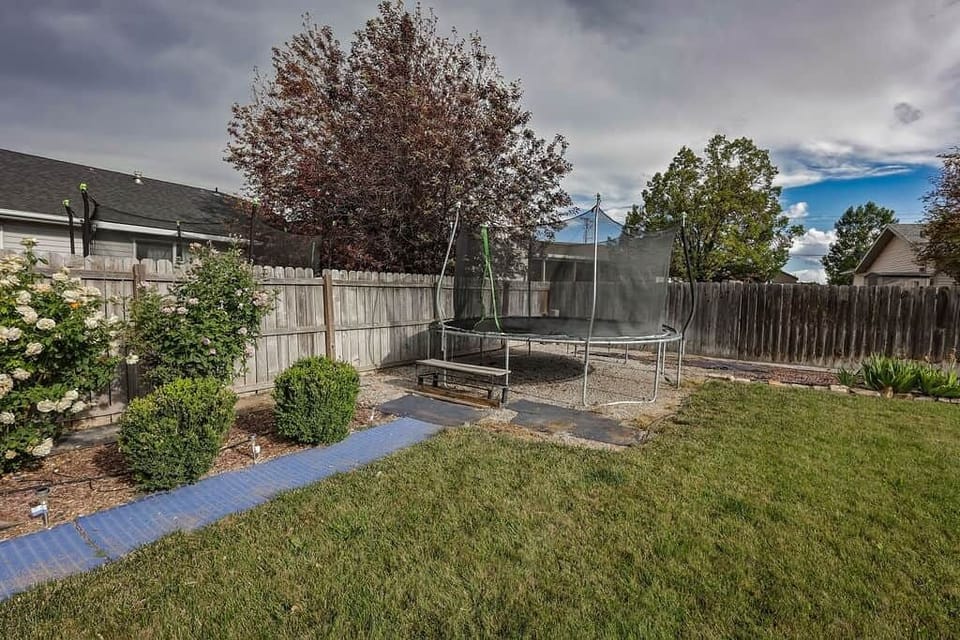 Trampoline in the fenced yard for bouncing and backyard fun