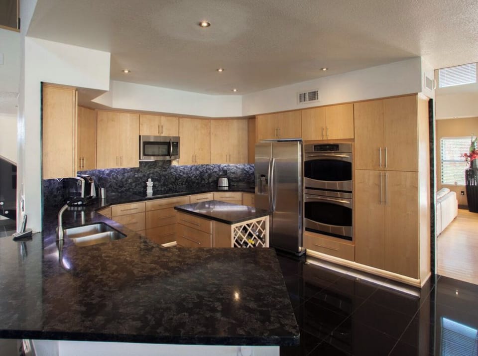 Large fully equipped kitchen, overlooks swimming pools & second Living + 85" TV