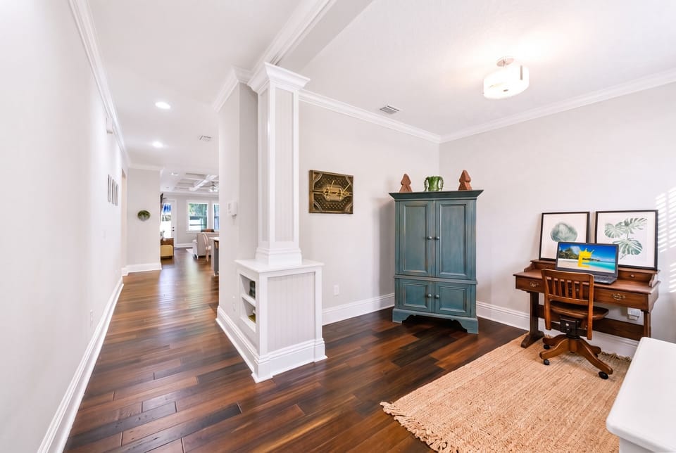Step into a bright and inviting entry featuring a dedicated workspace, stylish décor, and beautiful hardwood floors.
