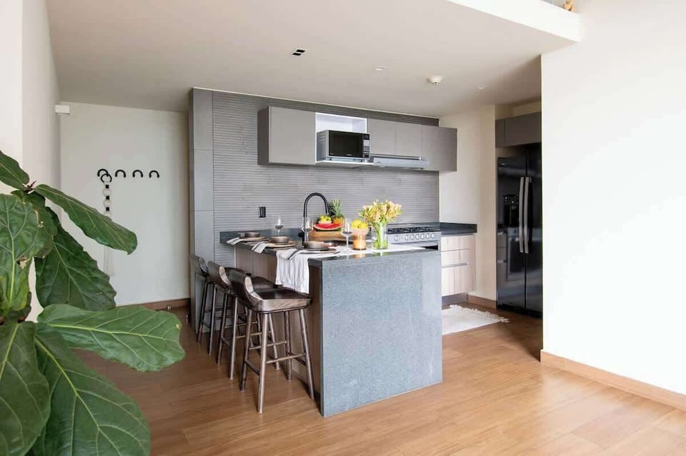 The central island creates a natural gathering spot for morning coffee, casual meals, or sharing a glass of wine while preparing dinner together.