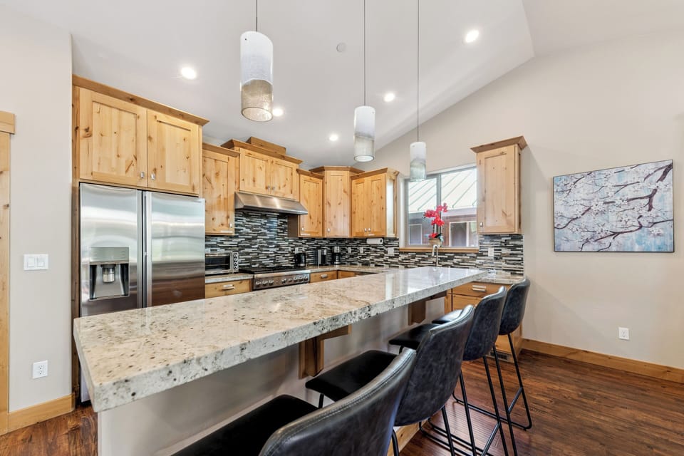 You'll love gathering in this spacious chef's kitchen with granite countertops, modern appliances, stylish pendant lighting, and a welcoming breakfast bar perfect for morning coffee or evening meals together.