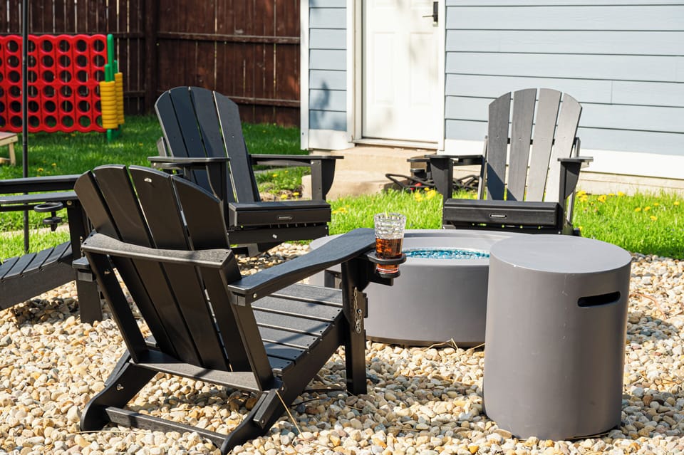 Cozy backyard fire pit with Adirondack seating and yard games
