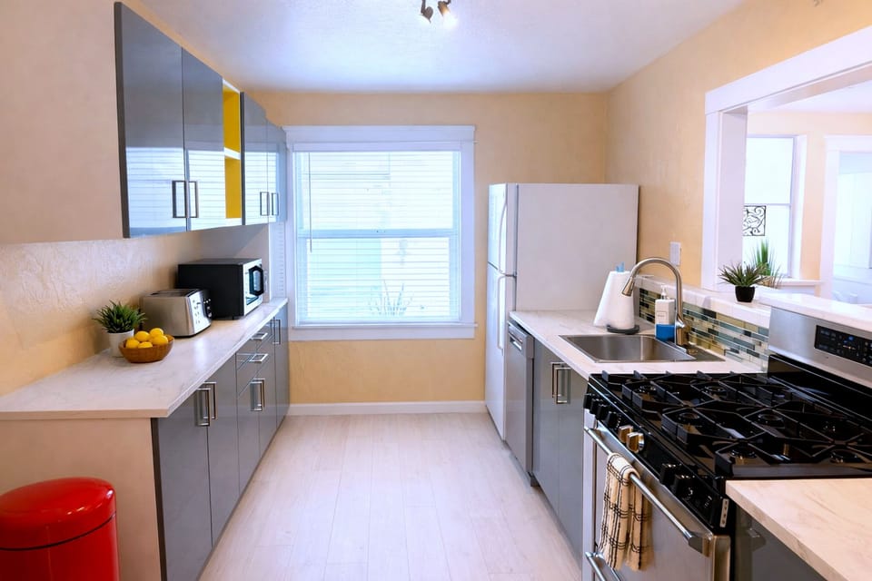 Bright modern galley kitchen with gas range, dishwasher, and coffee station