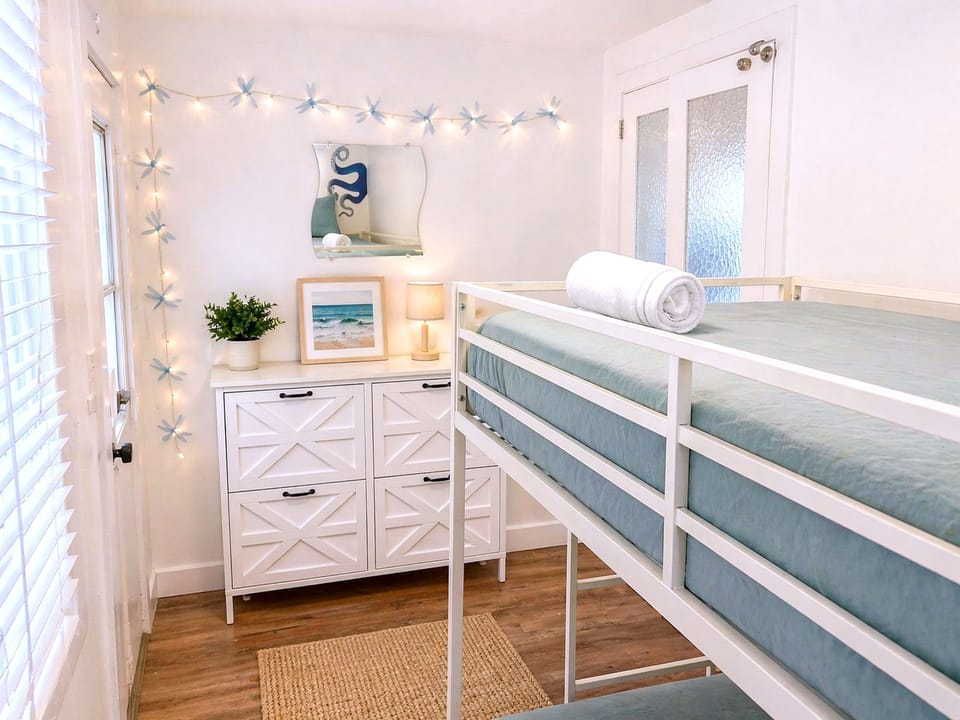 Sunny coastal bunk room with twinkle lights and stylish storage.