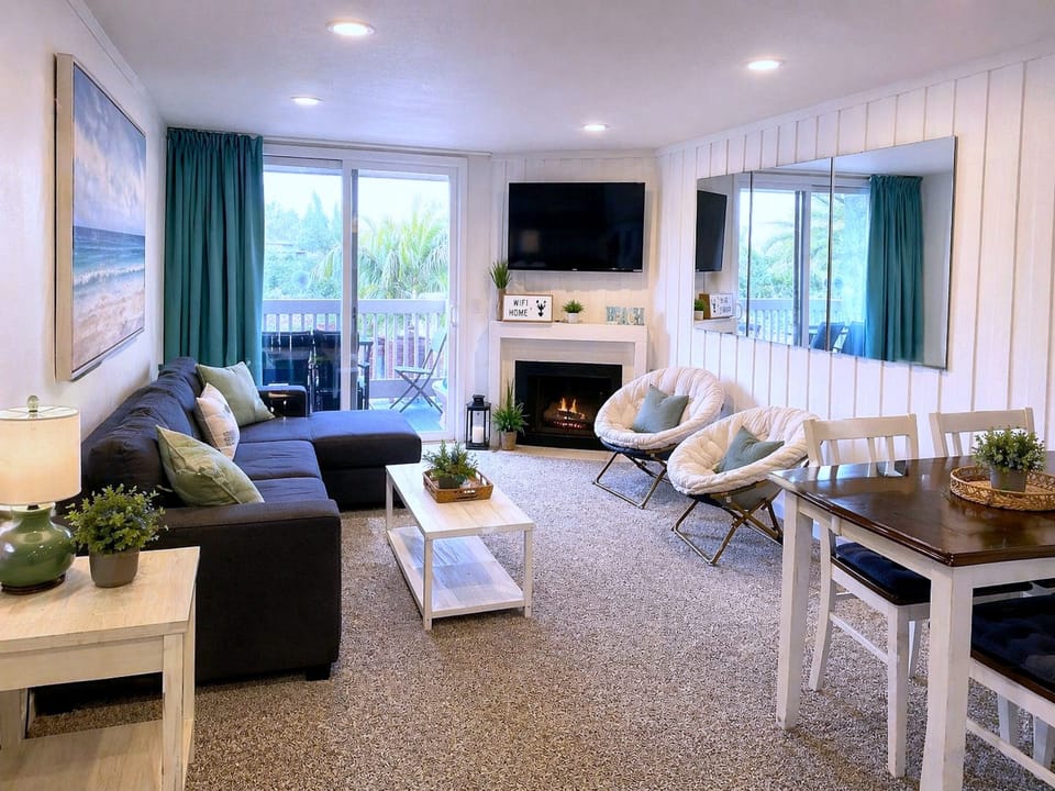 Coastal-chic lounge with fireplace, TV, and balcony retreat