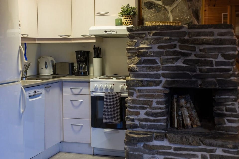Prepare your favorite meals with ease using the fully equipped kitchen space and provided appliances. The adjacent stone hearth adds a cozy, traditional feel to your cooking experience.