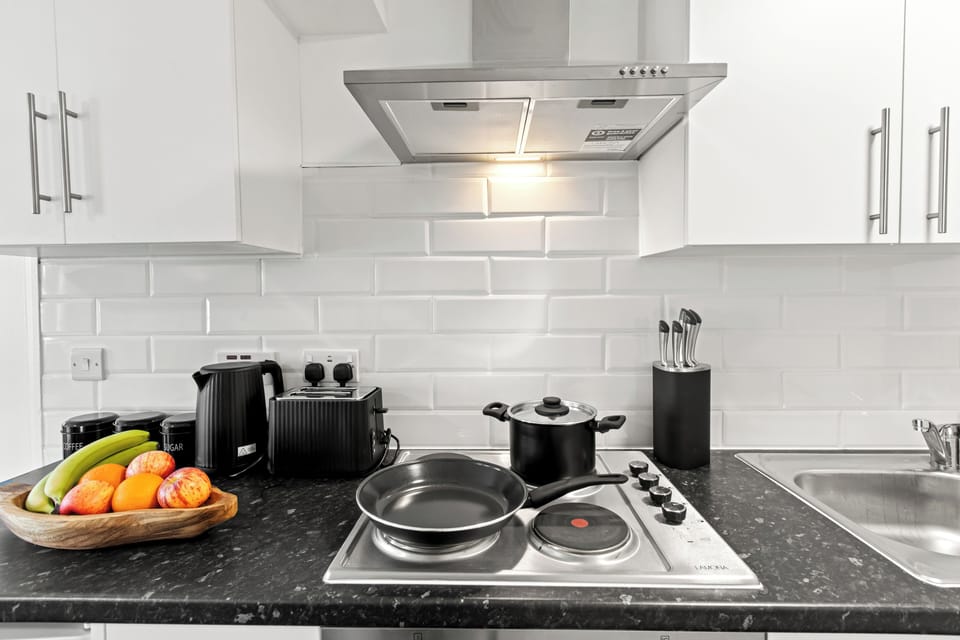 Bright, fully equipped kitchen with hob, toaster, and utensils