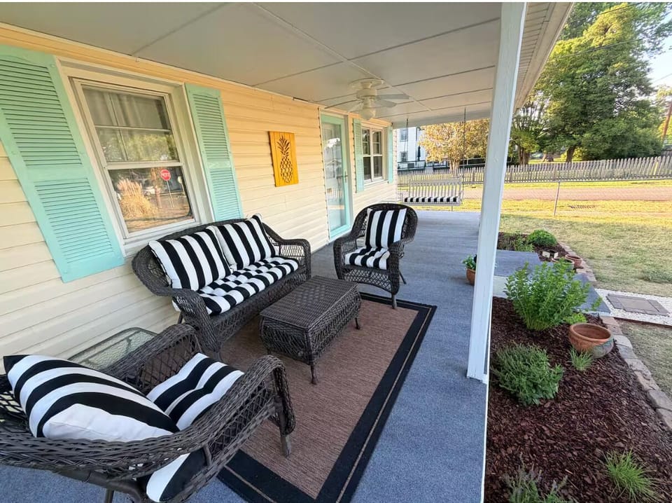 Covered porch with outdoor furniture and swing