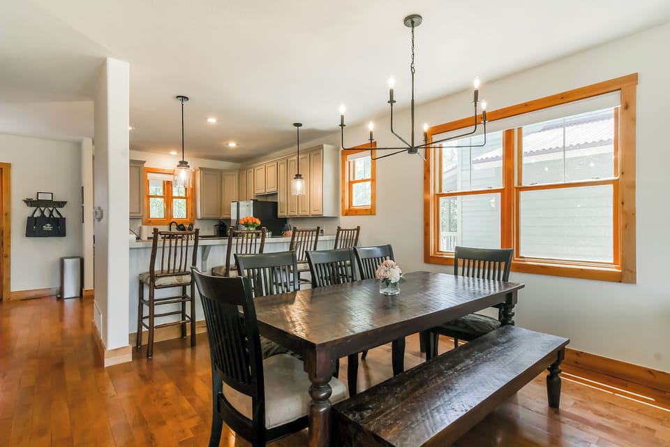 Gather everyone around the handsome farmhouse-style dining table where shared meals become cherished memories. Natural light pours through large windows while the open layout keeps you connected to the kitchen and living spaces.