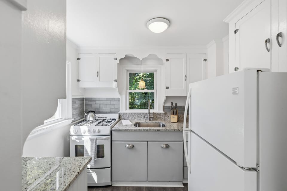 Bright updated kitchen with granite counters and charming window view