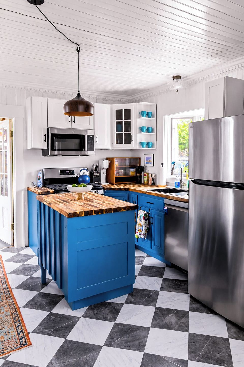 Bright designer kitchen with blue island, butcher block & stainless appliances